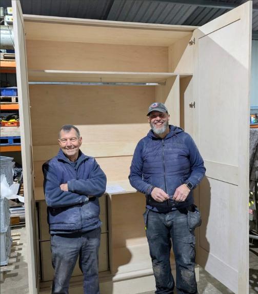 Craftsmen alongside a handmade cabinet